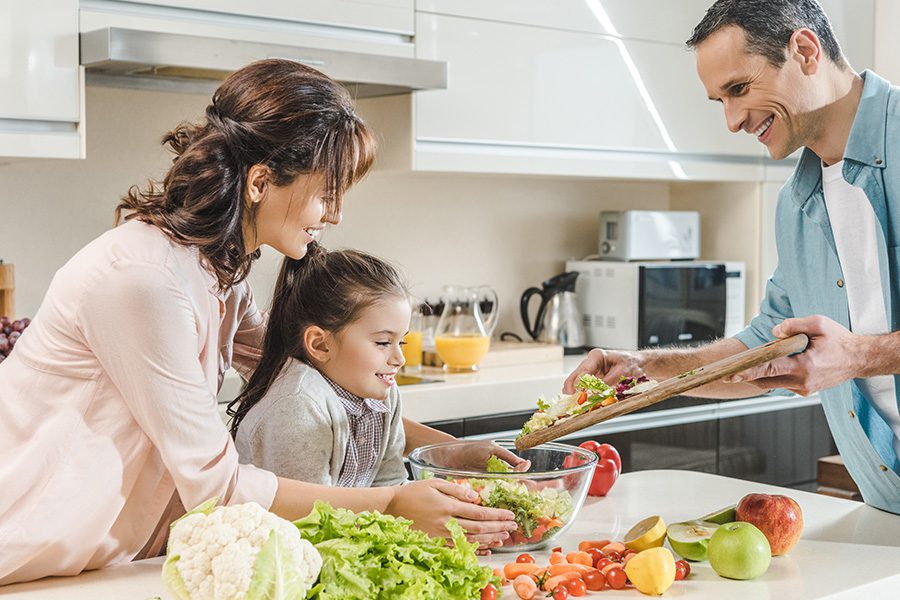 Personal Insurance - Happy Smiling Family Making Salad Together at the Kitchen